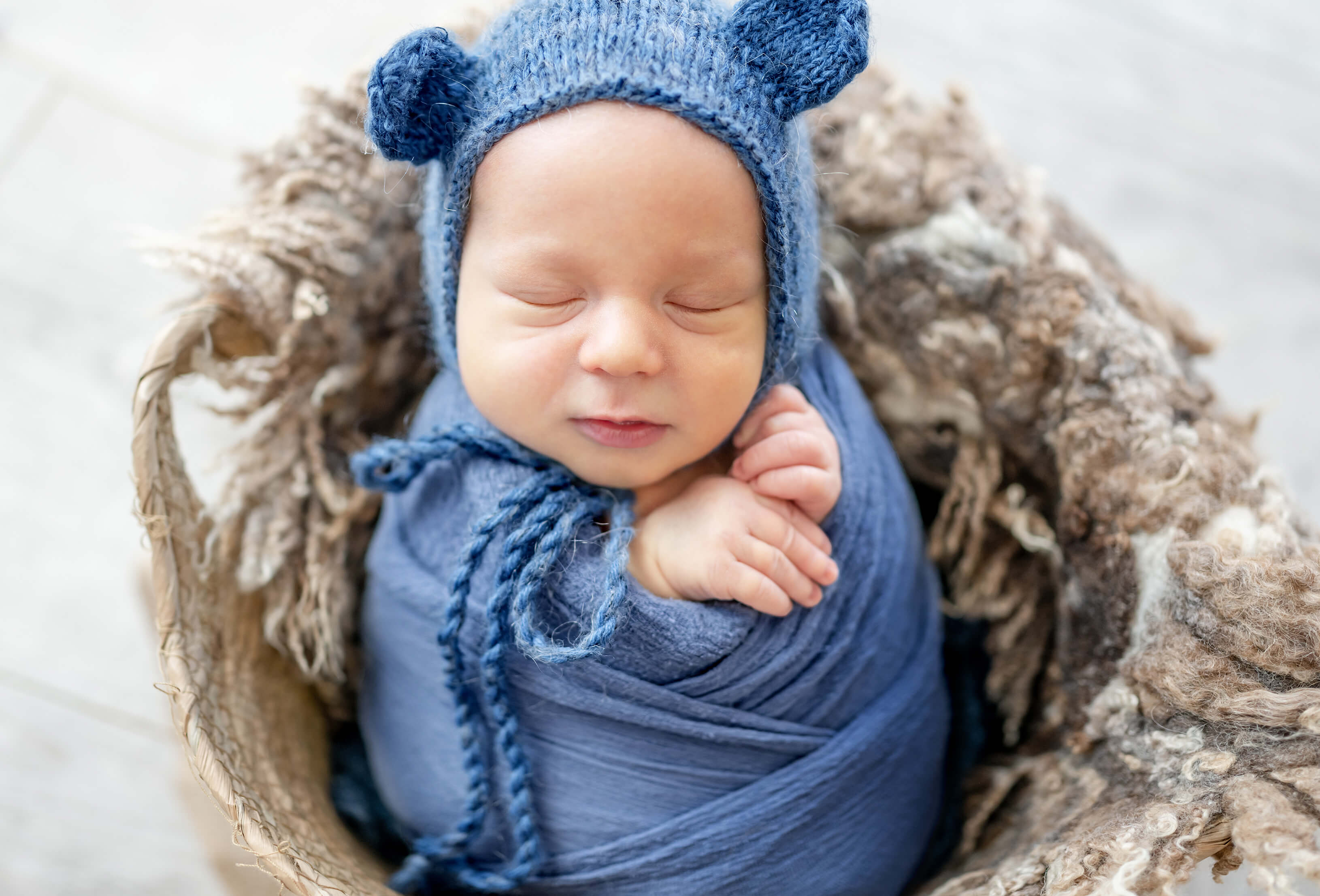 Ein schlafendes Baby (Junge) in Blau gekleidet mit Mütze