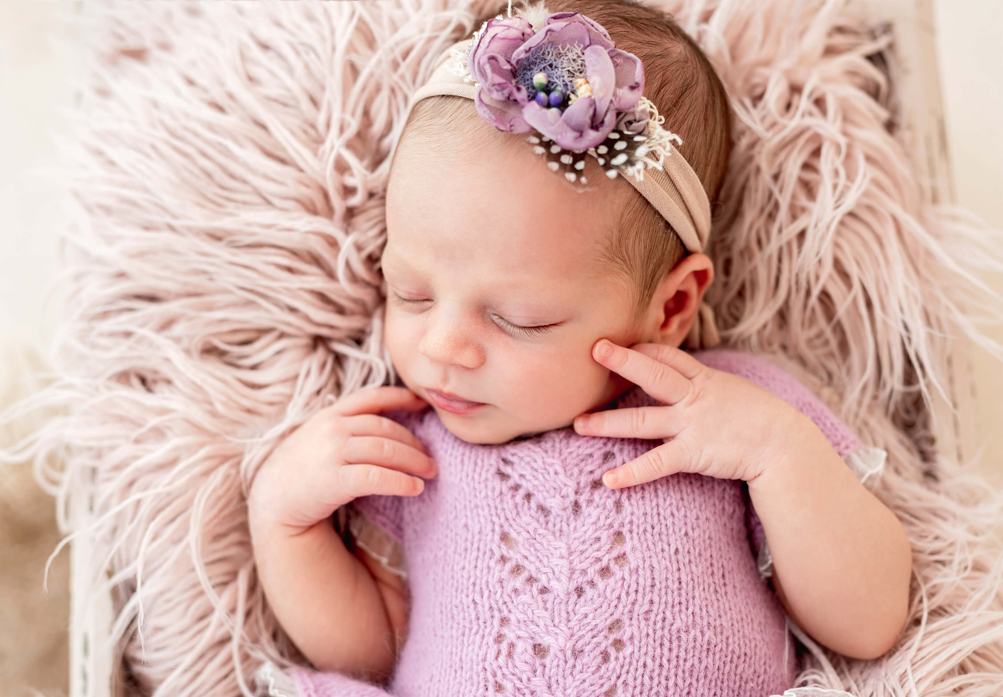 Ein schlafendes Baby (Mädchen) in Rosa gekleidet mit Haarband