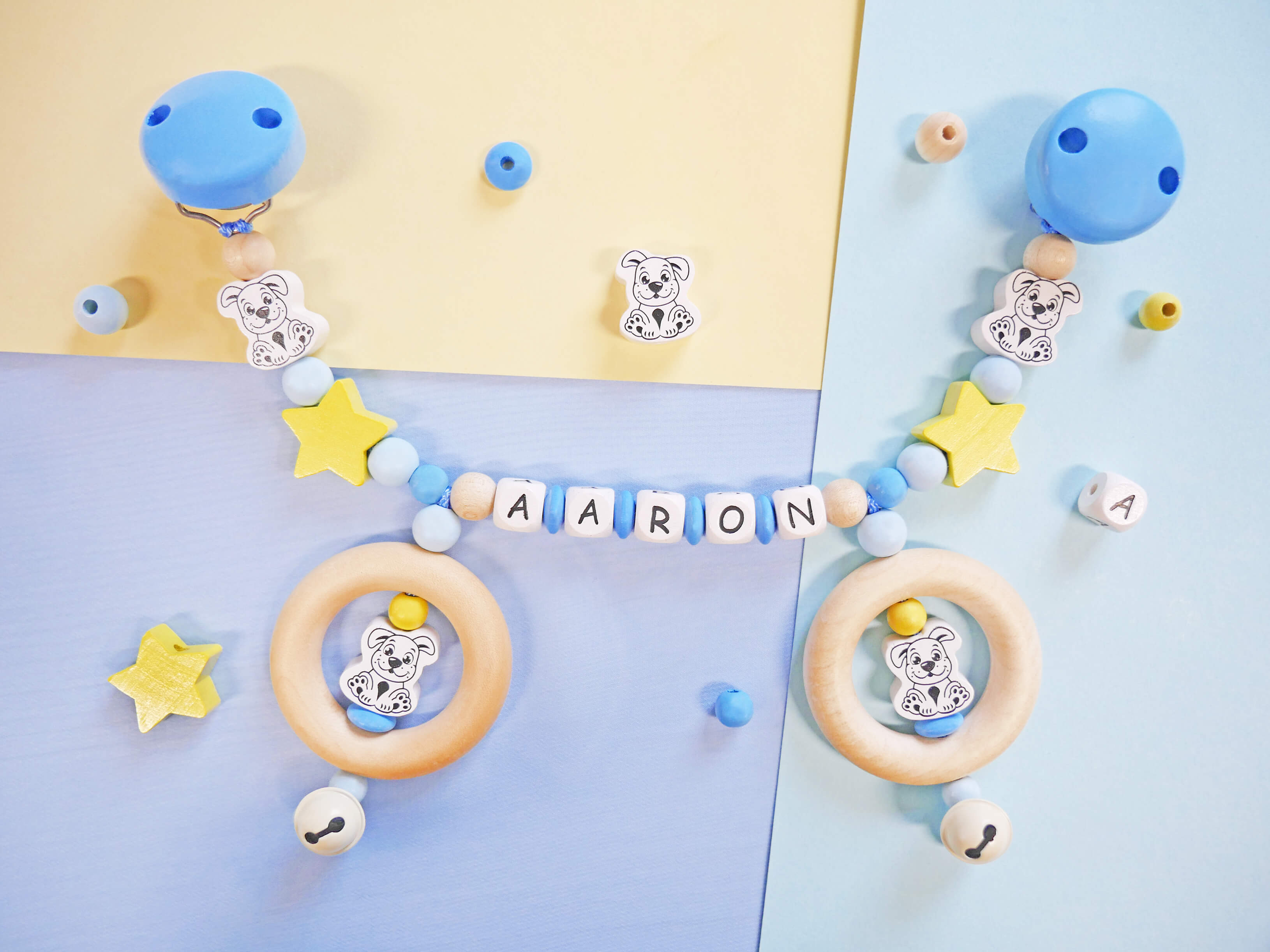 Kinderwagenkette in Skyblau, Babyblau und Pastellgelb mit Hunde- und Stern-Motivperlen