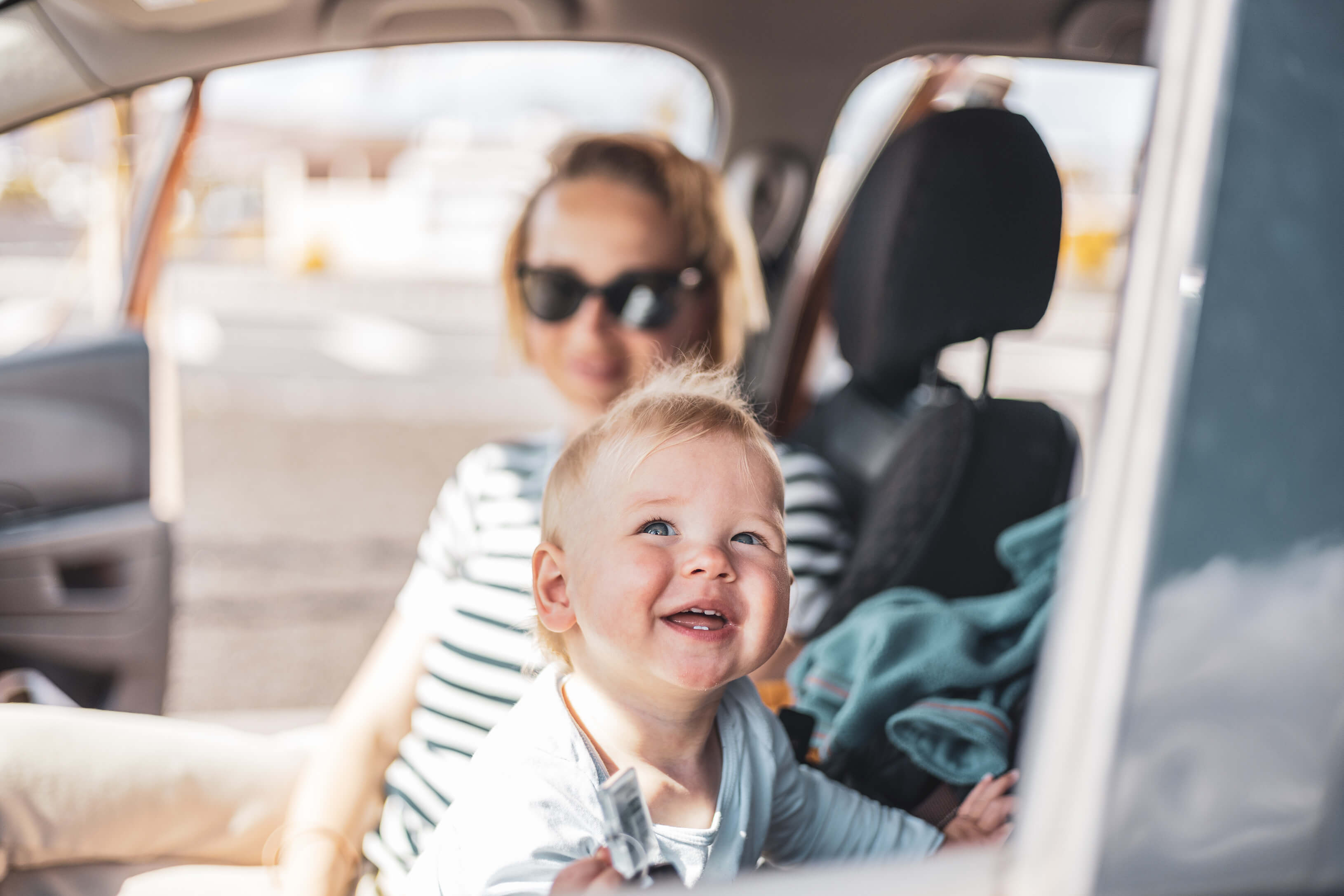 Mutter mit lachendem Baby im Auto
