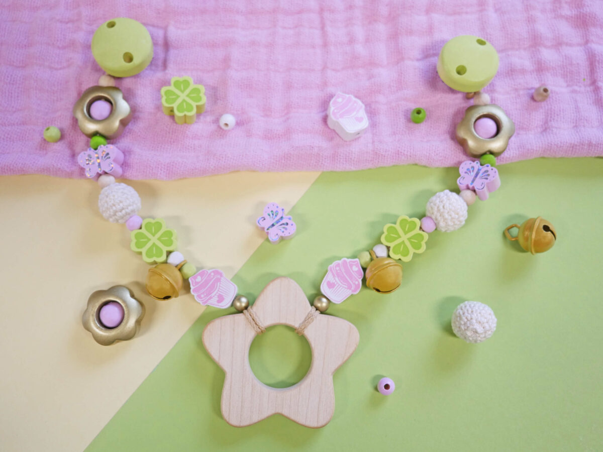 Kinderwagenkette in Rosa und Lemon und aus rohen Perlen mit Blumen-, Schmetterlings- und Kleeblätter-Motivperlen