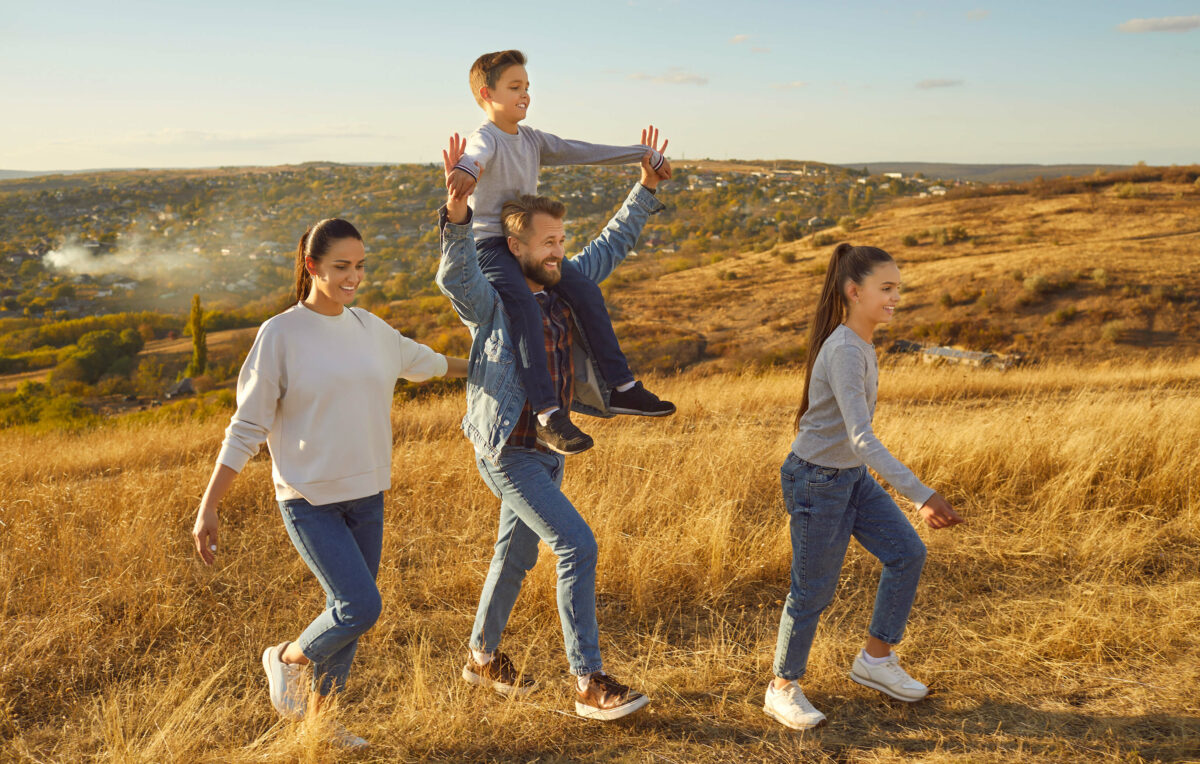 Eine fröhliche Familiemacht einen Sparziergang als Familienritual