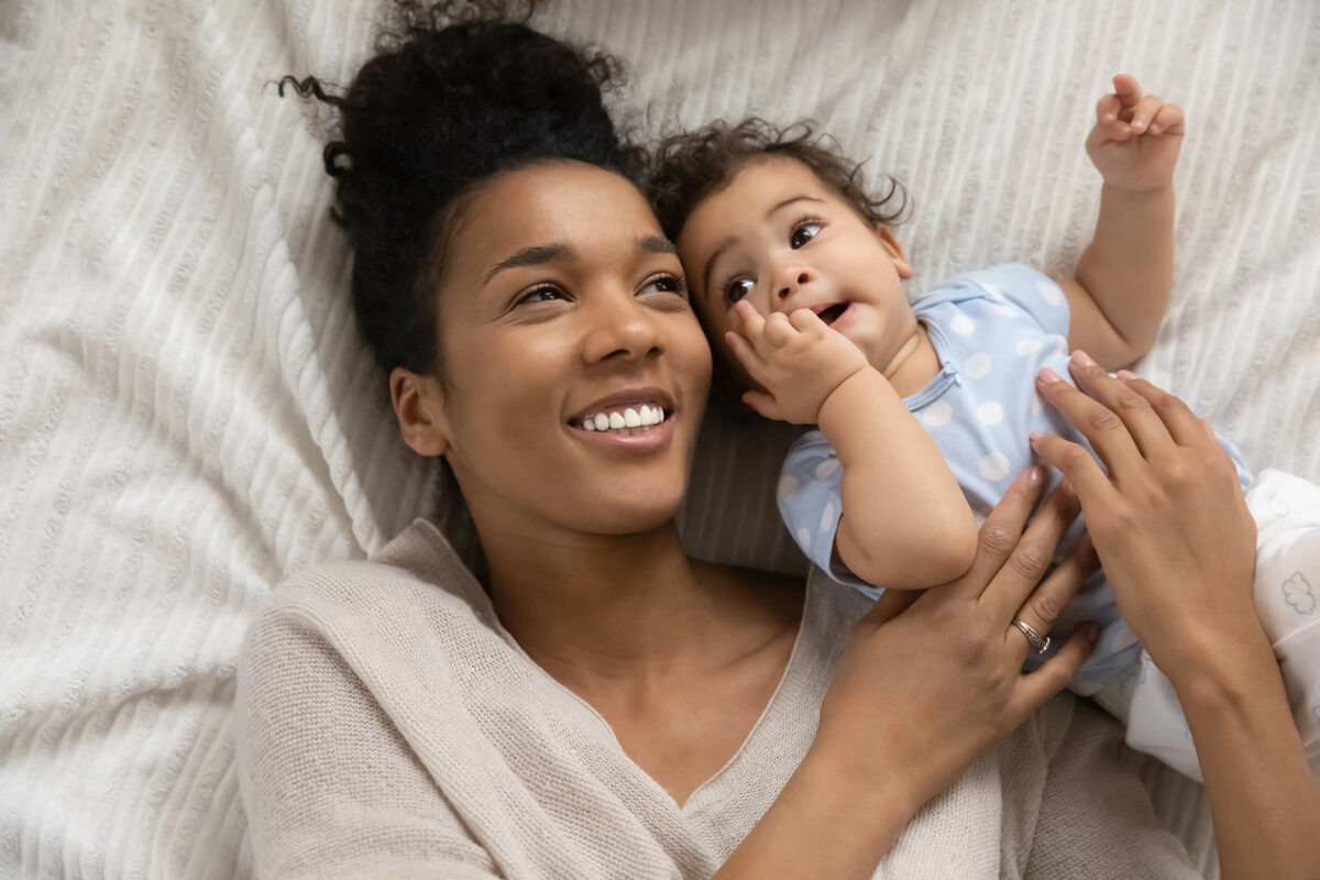 Mutter und Baby kuscheln lächelnd