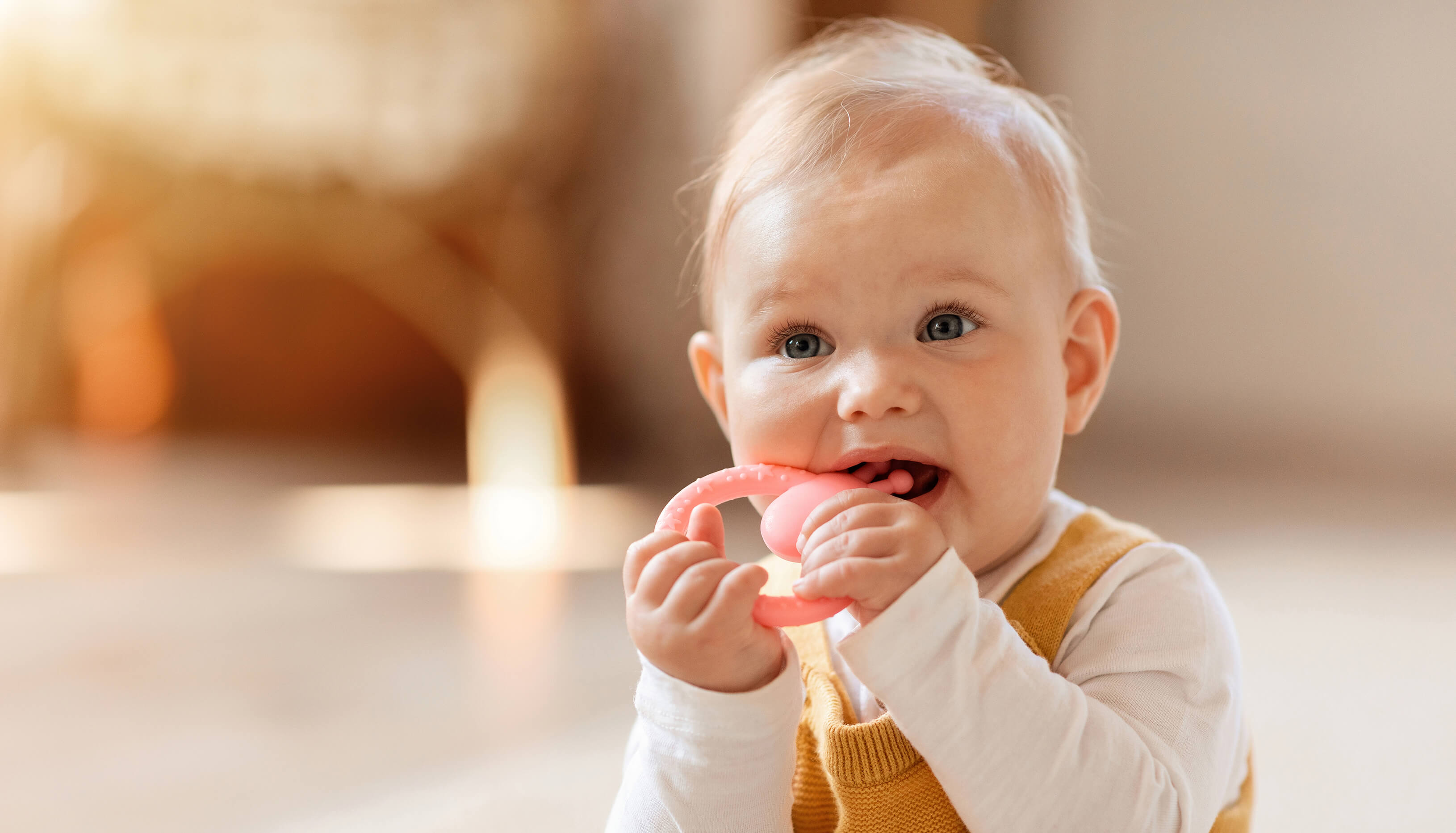 Baby beim Zahnen mit Beißring, Beißanhänger